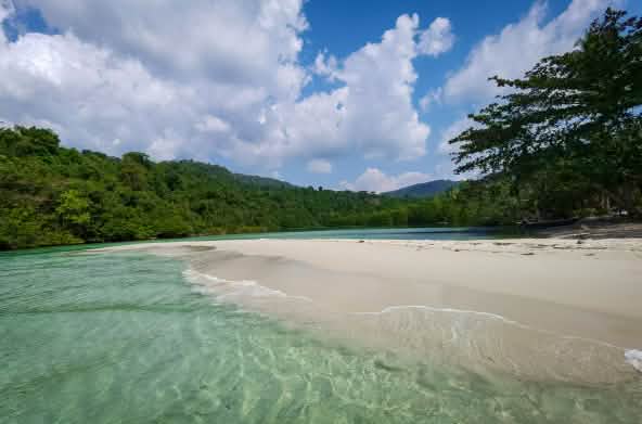 Een lagune op Koh Kong Island met helderwit zandstrand, op de achtergrond het bos