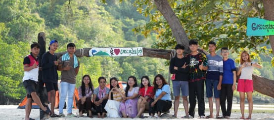 Campagne voor Koh Kong Island: Het jonge team van Mother Nature Cambodia wil het eiland beschermen tegen uitbuiting (© Mother Nature Cambodia) Een groep jonge mensen zit en staat voor een boom op het strand