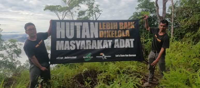 Op de berg Serayukan Beschreibung Udin en Habibi met spandoek