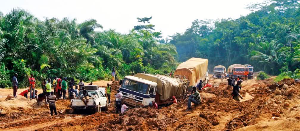 Vrachtwagen die vast zijn gelopen in de modder, Liberia
