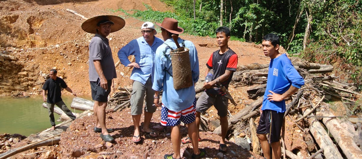 Inheemse mensen staan op een weg die houthakkers illegaal hebben aangelegd in Sarawak