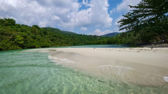 Een lagune op Koh Kong Island met helderwit zandstrand, op de achtergrond het bos