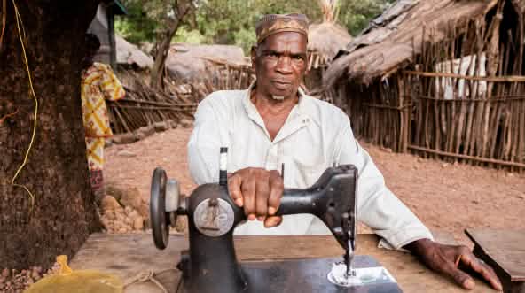 Kleermaker in Hamdallaye, Guinee, Sangaredi-bauxietmijn