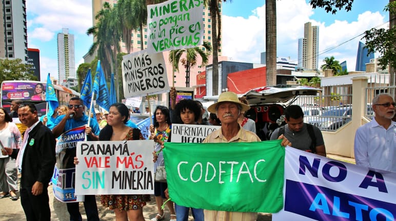 Mensen met handgetekende plakkaten protesteren tegen mijnbouw in de hoofdstad Panama