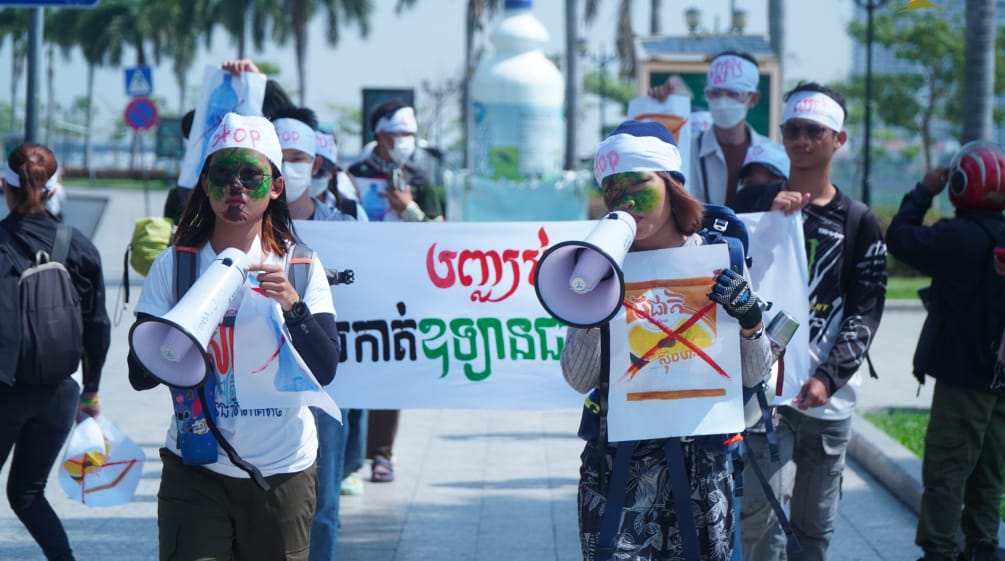 Een groep jonge studenten loopt met megafoon en spandoeken door een straat